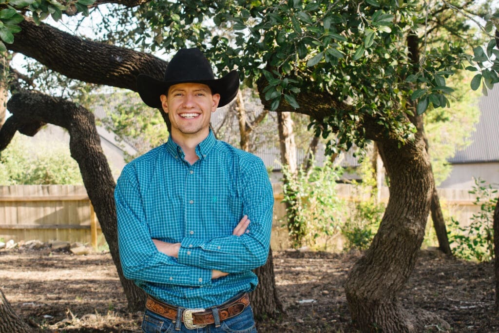 Riley Skinner, owner of Ridge Rock Builders, beside a large oak tree