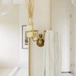 Brass wall sconce lighting detail in a remodeled bathroom