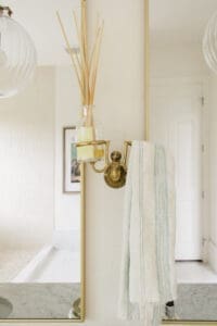 Brass wall sconce lighting detail in a remodeled bathroom