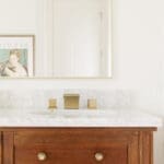 Brass widespread faucet on a marble vanity in a remodeled bathroom