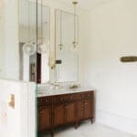 Vanity mirror and brass sconces in a remodeled Hill Country bathroom