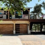Two-story party barn with balcony and roll-up doors in the Hill Country