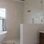 Bright remodeled bathroom with freestanding tub and brass fixtures