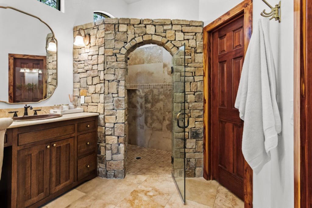 Custom home interior entryway with stone wall and wood door in Dripping Springs TX by Ridge Rock Builders