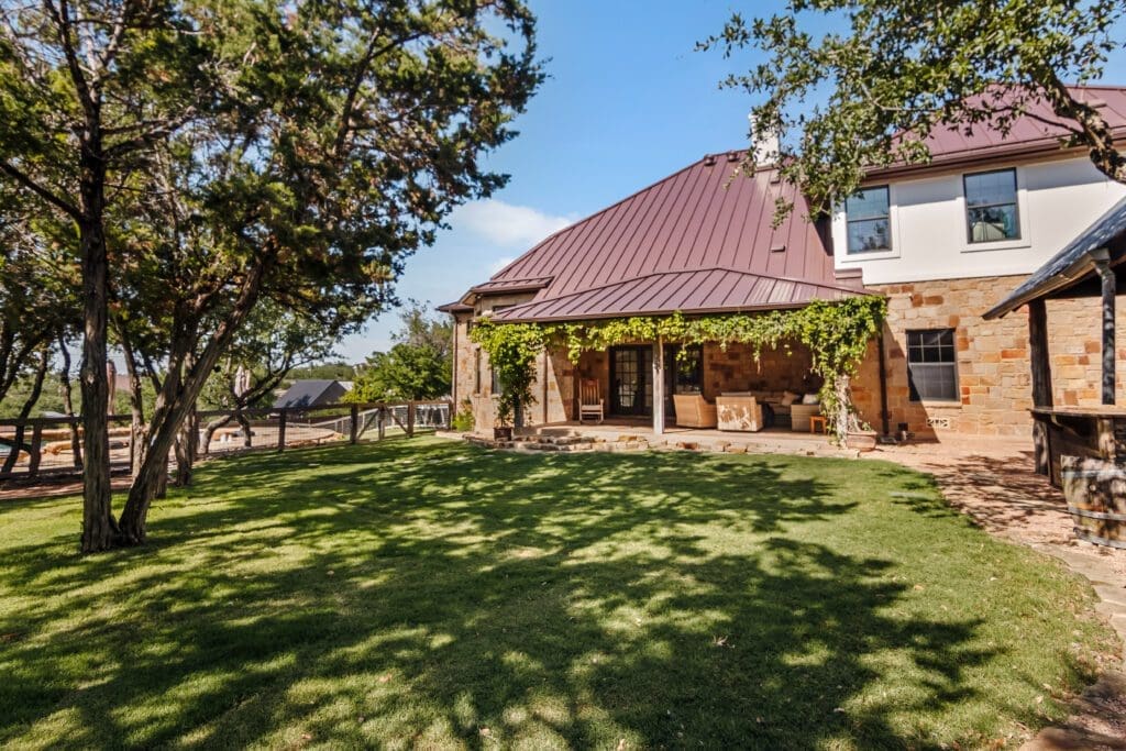Custom home exterior large backyard with mature trees in Texas Hill Country by Ridge Rock Builders