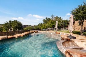 Custom home outdoor pool with rock water feature in Dripping Springs TX by Ridge Rock Builders