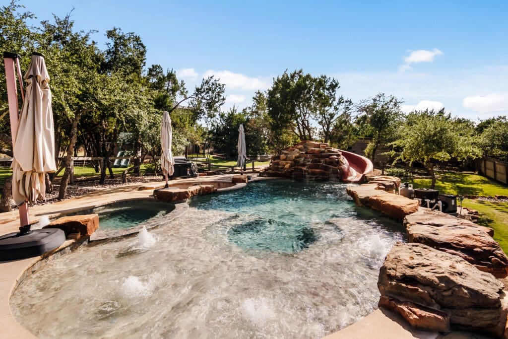 Custom home outdoor pool and water feature in Dripping Springs TX by Ridge Rock Builders