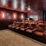 Home theater with tiered leather seating in a custom Hill Country home