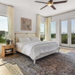 Bedroom with French doors and Hill Country views in a custom home by Ridge Rock Builders