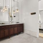 Bathroom vanity with double sinks and wood cabinetry in a custom Hill Country home