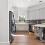 Casita kitchen with white cabinetry and breakfast bar in a guest house