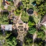 Aerial view of a custom home with landscaped gardens and stone patios in the Hill Country