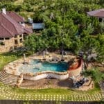 Custom stone home with rock pool and landscaped backyard in Dripping Springs