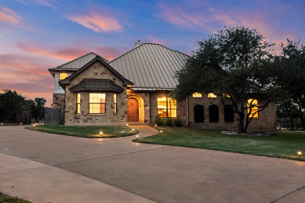 Custom home exterior at twilight in Dripping Springs TX by Ridge Rock Builders