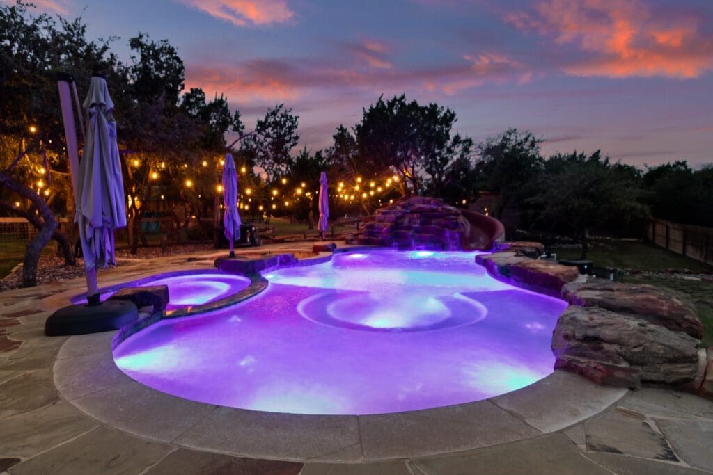 Custom home exterior at twilight in Dripping Springs TX by Ridge Rock Builders