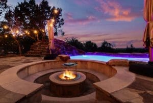 Fire pit and lighted pool at night at a custom Hill Country home
