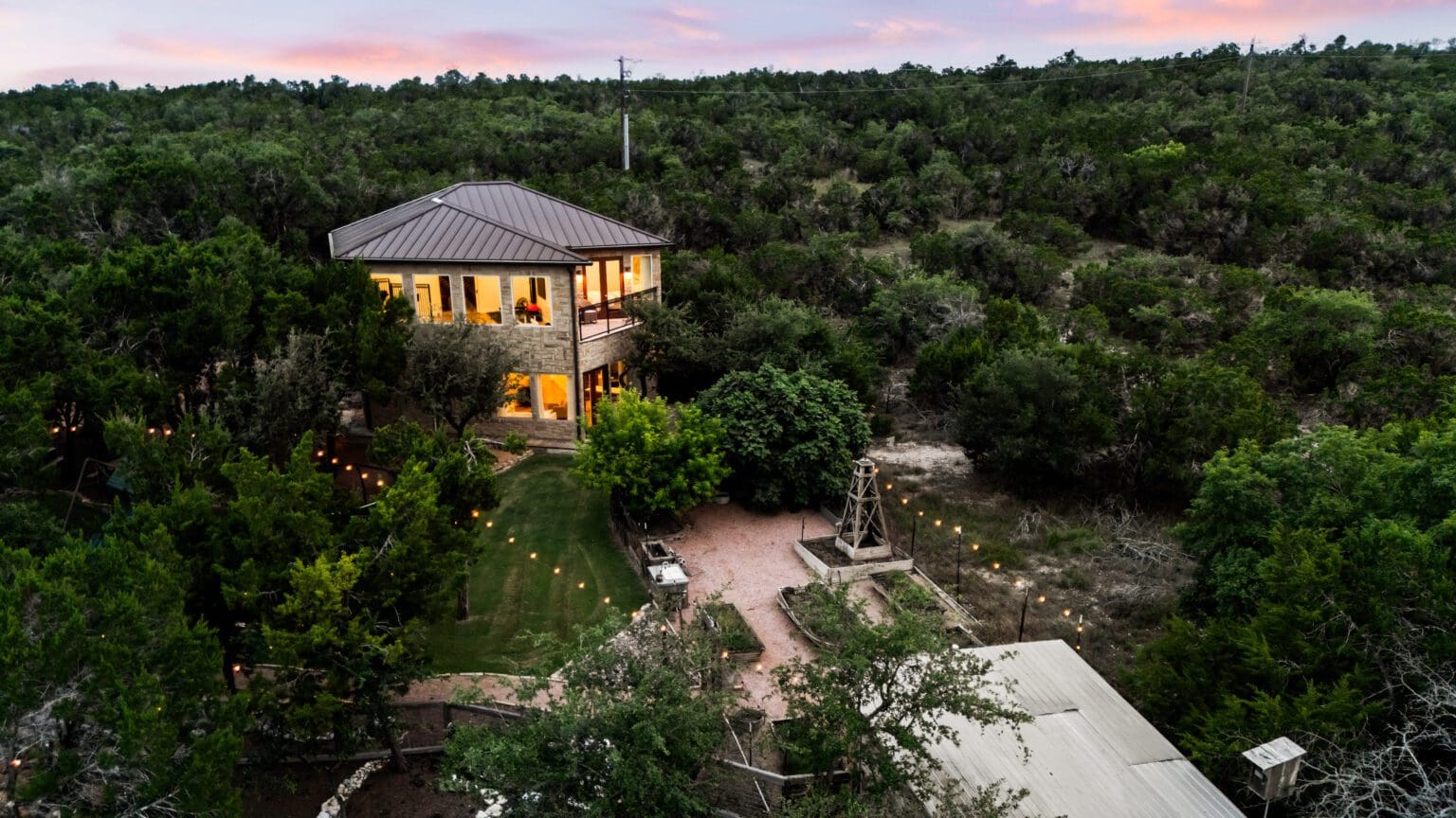 Custom home exterior at twilight in Dripping Springs TX by Ridge Rock Builders