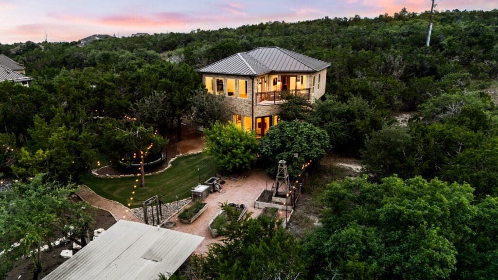 Aerial view of custom home at twilight in Dripping Springs TX by Ridge Rock Builders