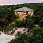 Two-story casita lit at night with landscape path lighting