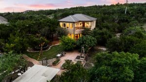 Aerial view of custom home at twilight in Dripping Springs TX by Ridge Rock Builders