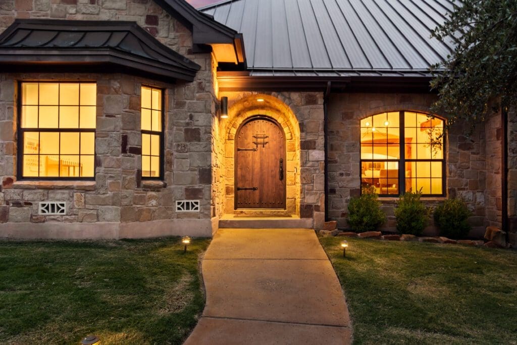 Custom home exterior at twilight in Dripping Springs TX by Ridge Rock Builders