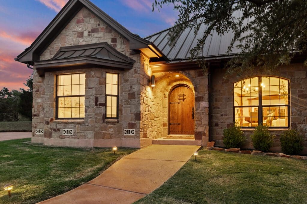 Custom home exterior at twilight in Dripping Springs TX by Ridge Rock Builders