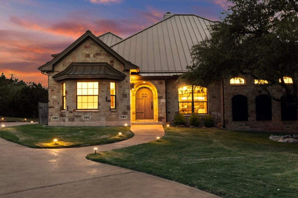 Custom home exterior at twilight in Dripping Springs TX by Ridge Rock Builders