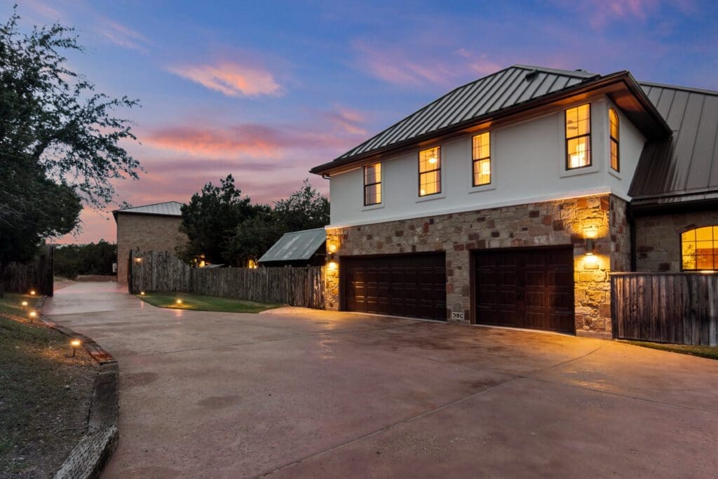 Custom home exterior at twilight in Dripping Springs TX by Ridge Rock Builders