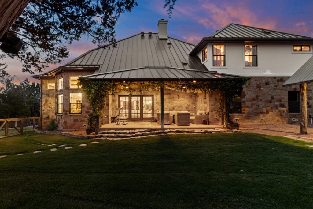 Custom home exterior at twilight in Dripping Springs TX by Ridge Rock Builders