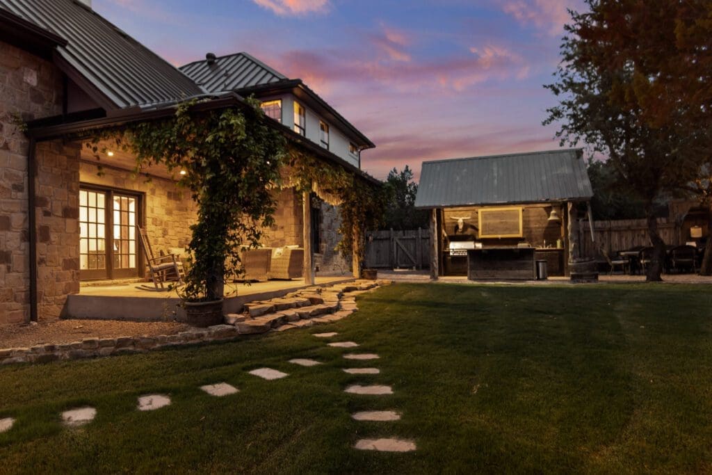 Custom home exterior at twilight in Dripping Springs TX by Ridge Rock Builders