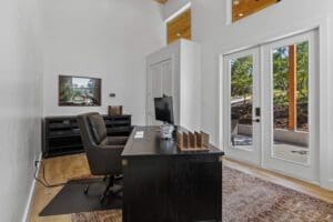 Home office with dark wood desk and French doors in a casita