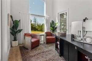 Casita office with leather chairs and a garden view window
